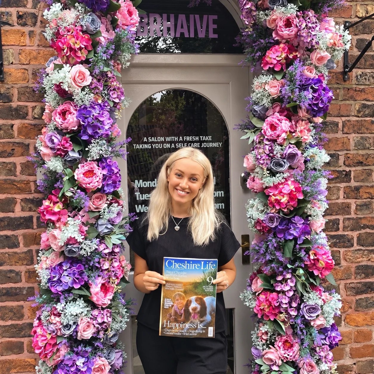 Leanne holding a BRHAIVE award outside the salon